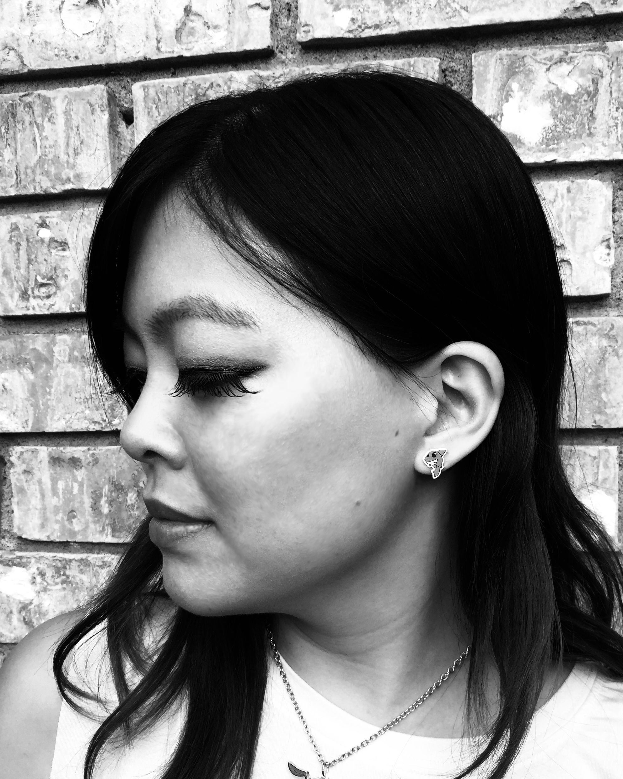 Kelsea Yu, a Taiwanese Chinese American femme. She has shoulder-length dark hair, long eyelashes, and a shark earring.