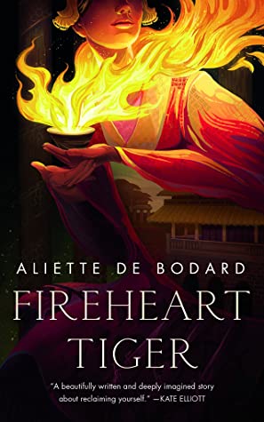 The cover of FIREHEART TIGER features a young femme in a drapey robe cupping a palmful of fire.